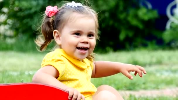 Funny cute child girl is playing on a slide. — Stock Video