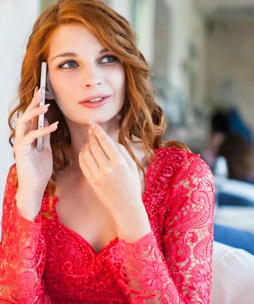 Aantrekkelijke vrouw in rode jurk praten op mobiele telefoon — Stockfoto