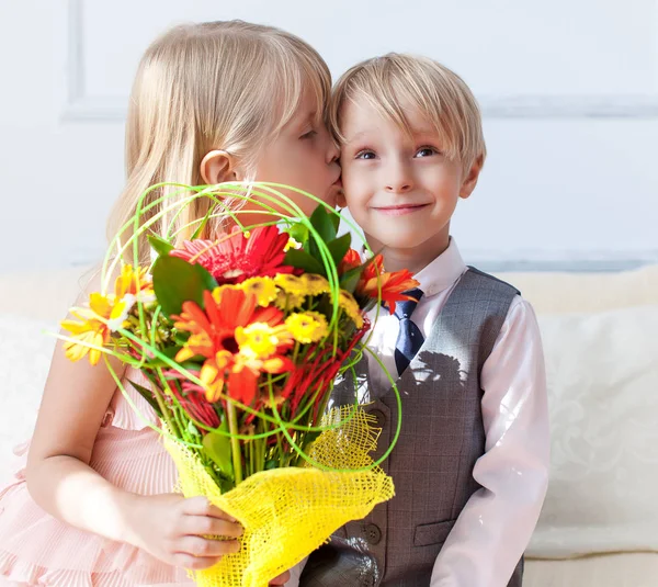 Happy little boy giving a bouquet for cute girl — Stock Photo, Image