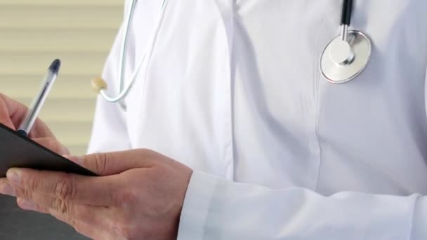 Médico varón médico escribiendo prescripción rx en portapapeles para sus pacientes — Vídeos de Stock