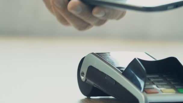 Clienti che pagano con la tecnologia NFC tramite telefono cellulare sul terminale POS — Video Stock