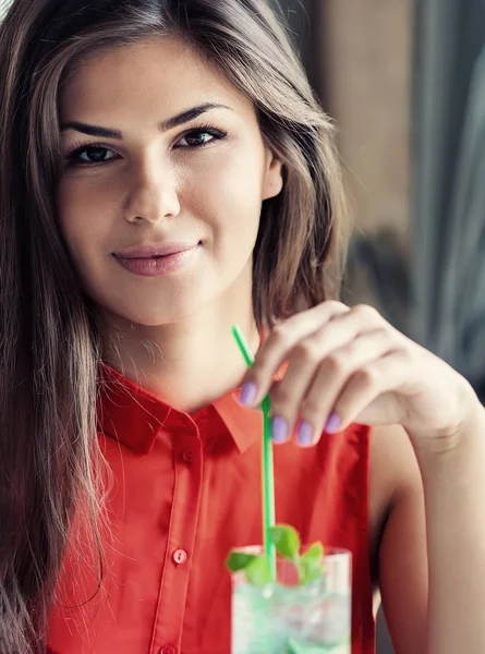 Schöne junge Frau im Café trinkt Mohito — Stockfoto