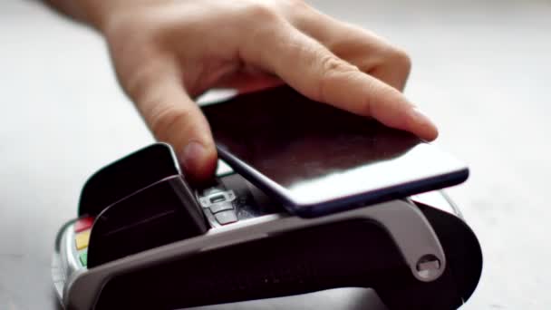 Person using contactless payment with smartphone. — Stock Video