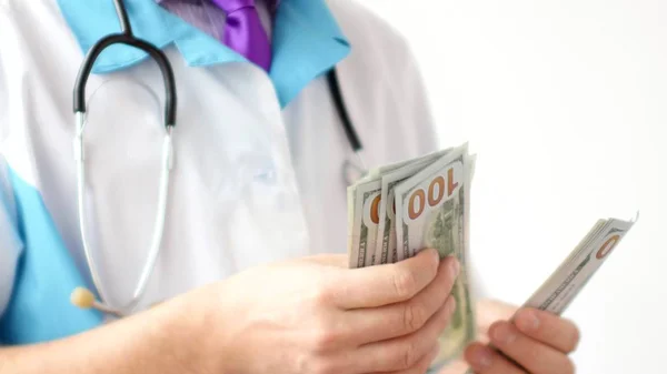 Männlicher Arzt, der Dollars aus nächster Nähe zählt. Korruption in der Medizin. — Stockfoto