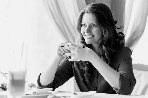 Młoda kobieta, picia kawy w kawiarni. Czarno-białe zdjęcie. — Zdjęcie stockowe