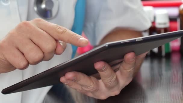 Médico masculino que trabaja con una tableta de pantalla táctil moderna — Vídeo de stock