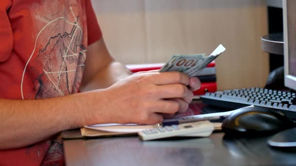 Mann zählt Geld und füllt Steuerformular aus — Stockvideo