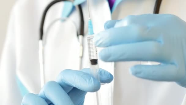 Close-up of doctor hands in protective gloves filling the syringe with medicine. — Stock Video