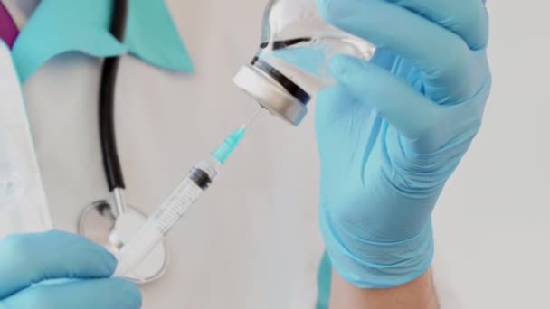 Крупный план рук врача в защитных перчатках, наполняющих шприц лекарствами . — стоковое видео
