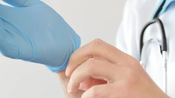Доктор надевает голубые латексные перчатки — стоковое фото