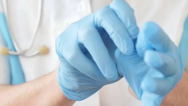 Doctor poniéndose guantes de látex azul —  Fotos de Stock