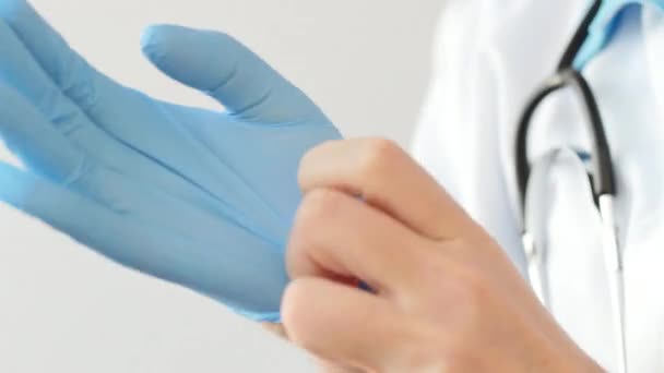 Doctor putting on blue latex gloves — Stock Video