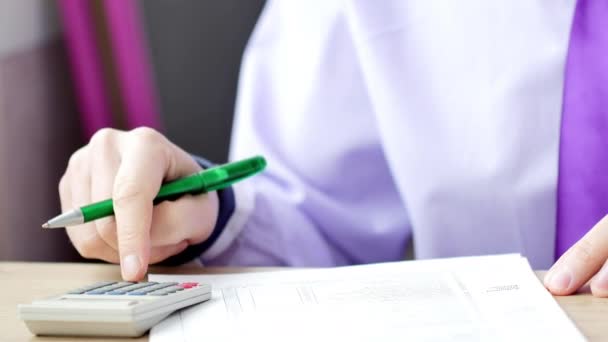 Hombre llenando formulario de impuestos o contrato. Está usando la calculadora. — Vídeos de Stock