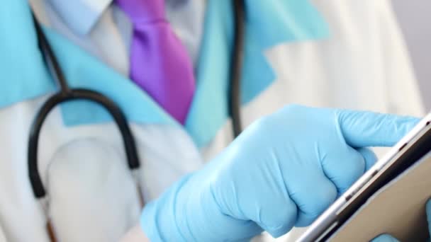 Medical doctor taking notes while touching digital tablet. — Stock Video