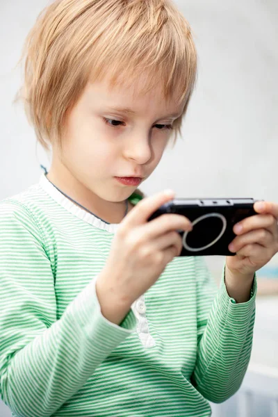 Мальчик, играющий в видеоигру на игровой консоли — стоковое фото