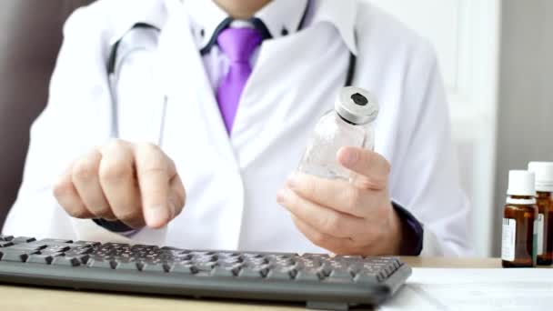 Медичний лікар працює на ноутбуці в своєму кабінеті і натискає комп'ютерну мишу — стокове відео