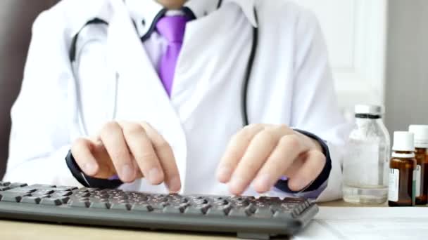 Médico médico trabajando en el ordenador portátil en su gabinete y haciendo clic en el ratón del ordenador — Vídeos de Stock