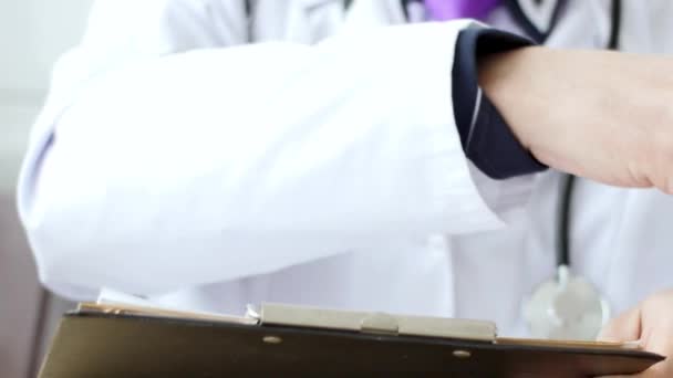 Closeup of male doctor hand writing a medical prescription. — Stock Video