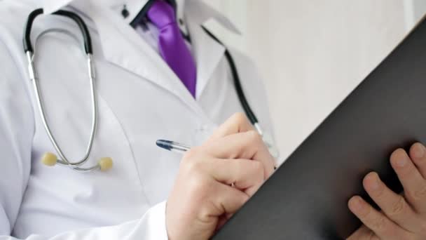 Closeup of male doctor hand writing a medical prescription. — Stock Video