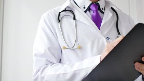 Fechar a mão do médico masculino que escreve uma prescrição médica . — Vídeo de Stock