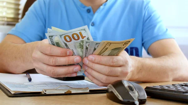 Hombre Camiseta Azul Contando Dólares Llenando Formulario Impuestos Calcula Gastos — Foto de Stock