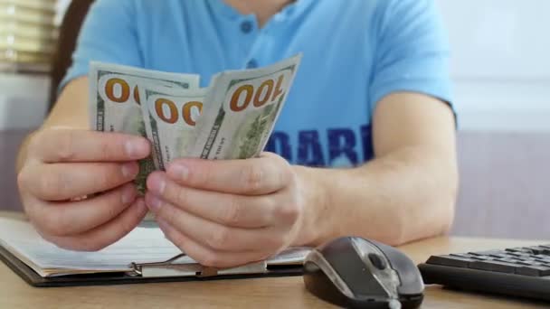 Hombre en camiseta azul contando dólares y llenando formulario de impuestos — Vídeo de stock