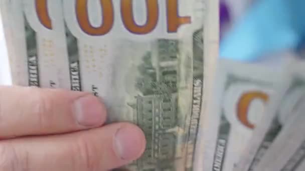 Mannelijke arts tellen honderd dollar biljetten — Stockvideo