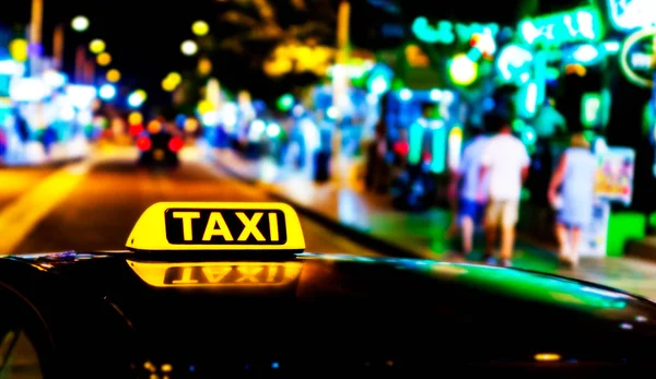 Iluminado con un cartel de taxi amarillo en el techo de un coche — Foto de Stock