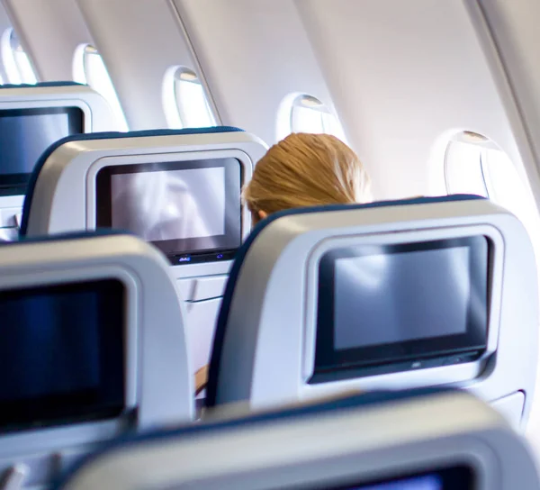 Люди, ищущие дисплеи ЖК-экранов на мониторах сидений самолета . — стоковое фото