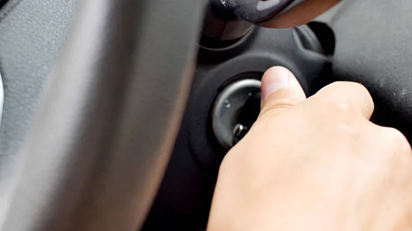 Mannelijke hand het plaatsen van autosleutel in slot en het starten van motor. — Stockfoto