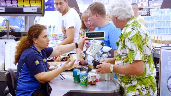 Clientes que pagan por comprar en un supermercado — Foto de Stock