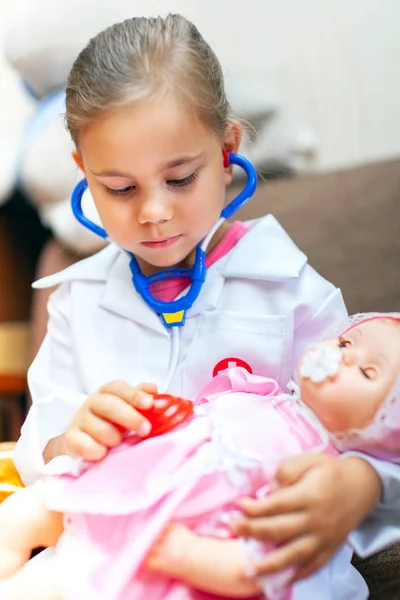 Menina bonito jogando médico com brinquedo boneca bebê — Fotografia de Stock