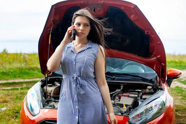 田舎道で壊れた車の女が携帯電話で電話をかけてる. — ストック写真