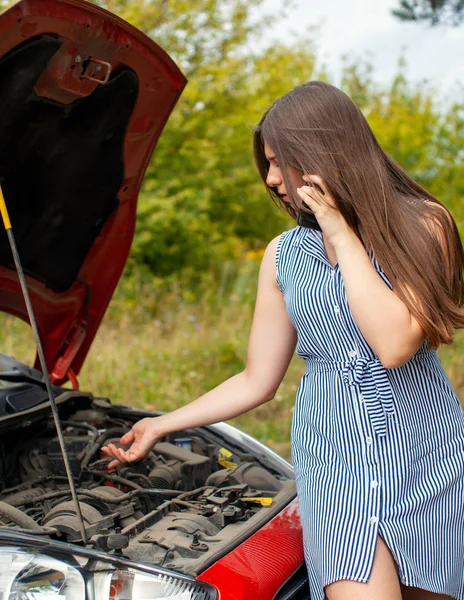 Frau mit kaputtem Auto auf Landstraße telefoniert mit Handy. — Stockfoto