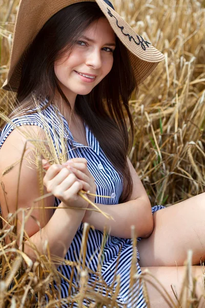 Young beautiful woman resting on golden field of wheat — Stock Photo, Image