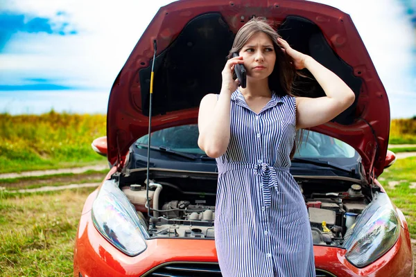 田舎道で壊れた車の女が携帯電話で電話をかけてる. — ストック写真