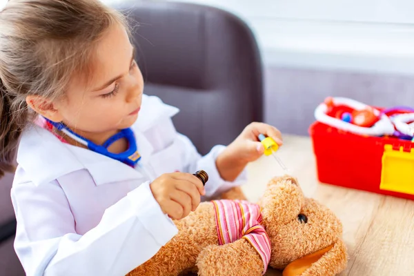 Menina bonito jogando médico com brinquedo de pelúcia — Fotografia de Stock