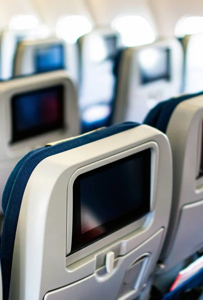 Aircraft interior with seats and blank touch screens displays. — Stock Photo, Image