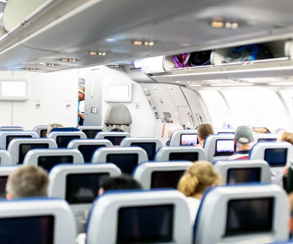 Aircraft interior with seats and blank touch screens displays. — Stock Photo, Image