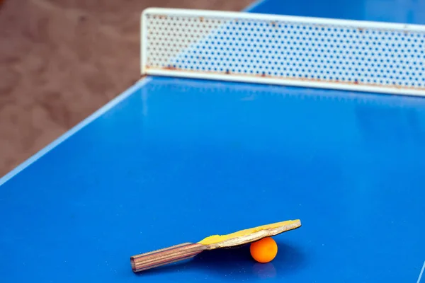 Table tennis or ping pong racket and ball on a blue table Royalty Free Stock Images