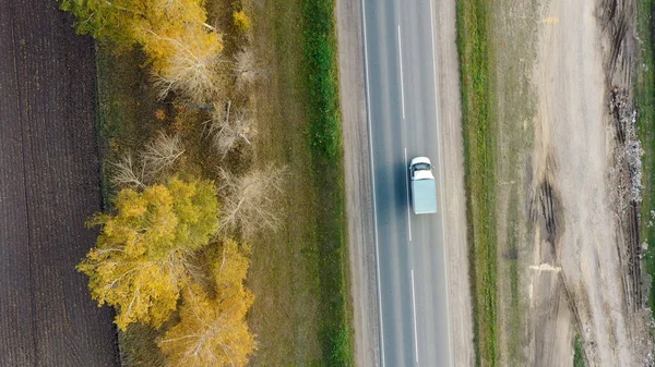 Vista aérea dos carros que conduzem na estrada do outono do país — Fotografia de Stock