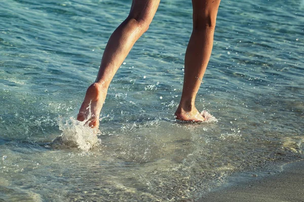 La mujer corre por delante en la playa del mar . — Foto de Stock