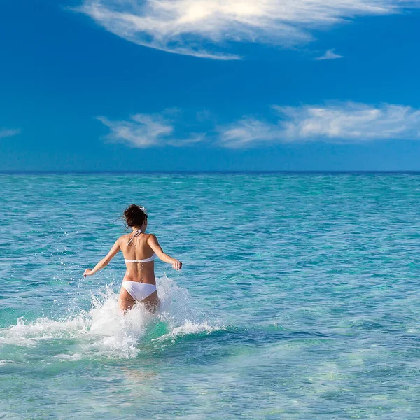 Menina bonita correndo para a água do mar — Fotografia de Stock