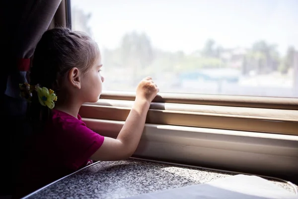 Glückliches kleines Mädchen, das mit dem Zug reist. — Stockfoto