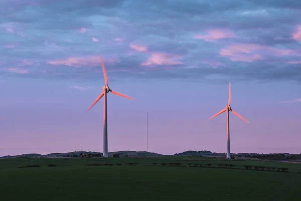 Two windmills in the field at sunset, Scotland