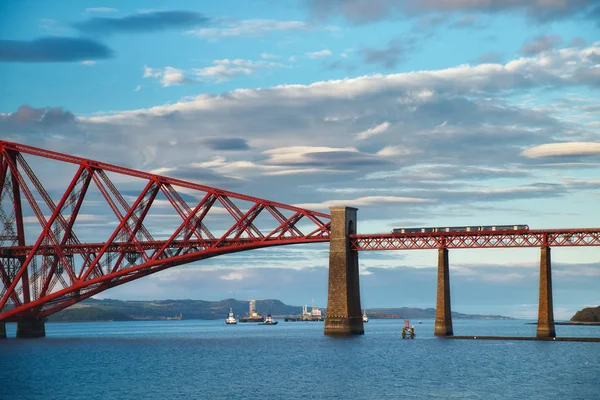 A train moving over a bridge over the sea. View of Forth Rail Bridge, the world's longest cantilever bridge, Scotland, United Kingdom