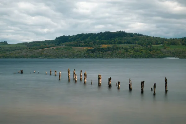 Utsikt över sjön med gamla trä pelare — Stockfoto