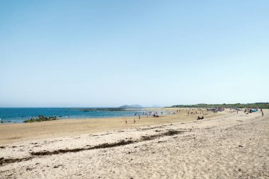 İnsanlar sahilde dinlenir.