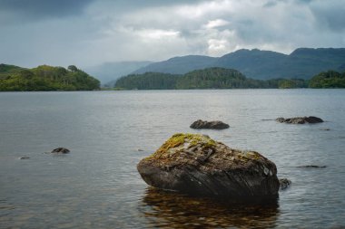 Büyük bir ön planda taşla İskoç gölü manzarası
