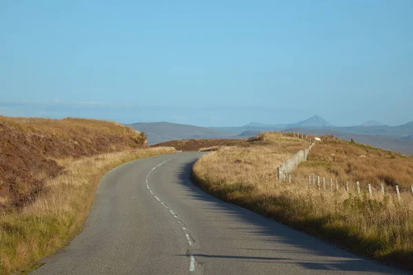 Camino de montaña curvado y valla — Foto de Stock